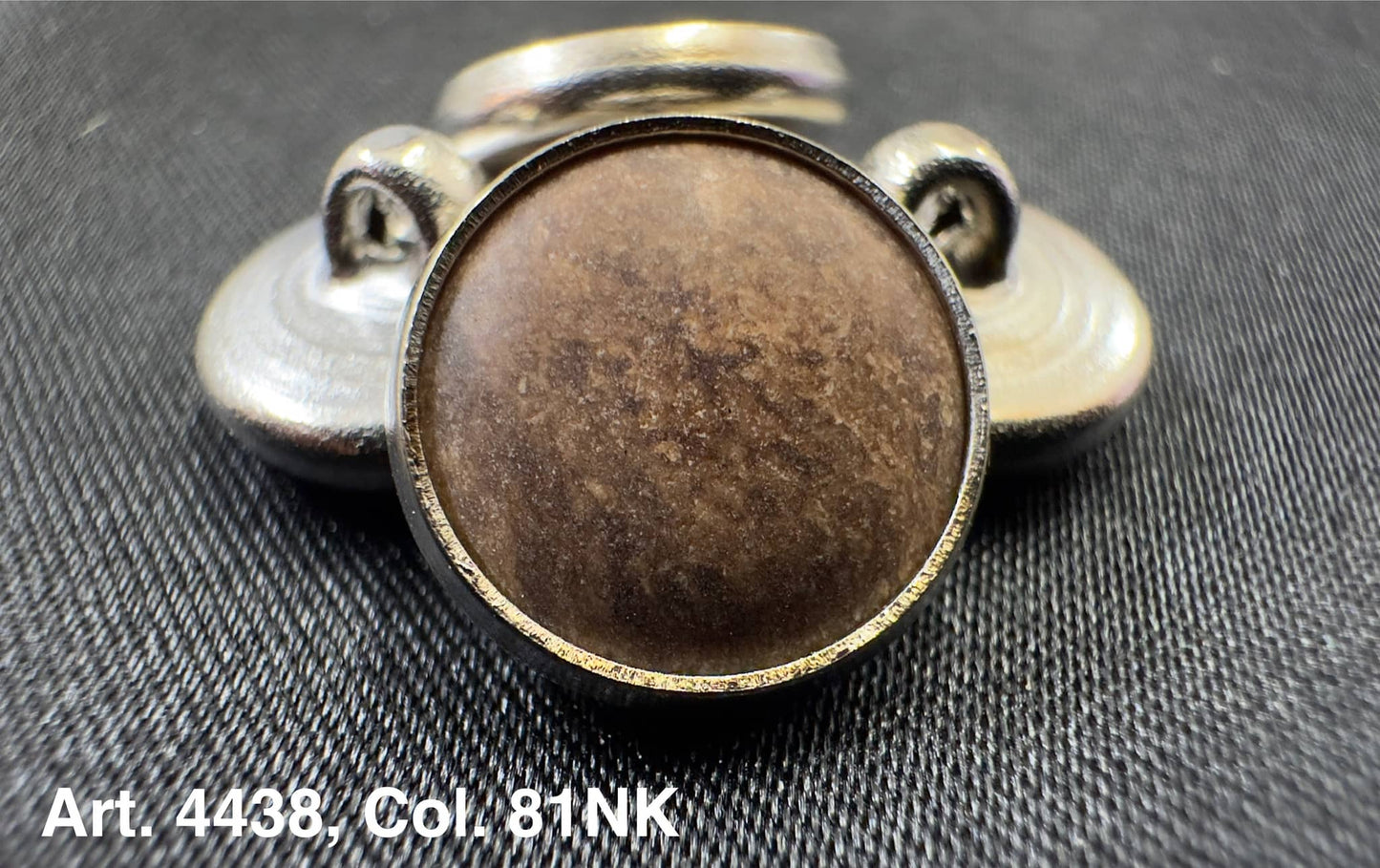 Buttonology Inc polyester garment shank with brown faux leather center and metal backing on black fabric