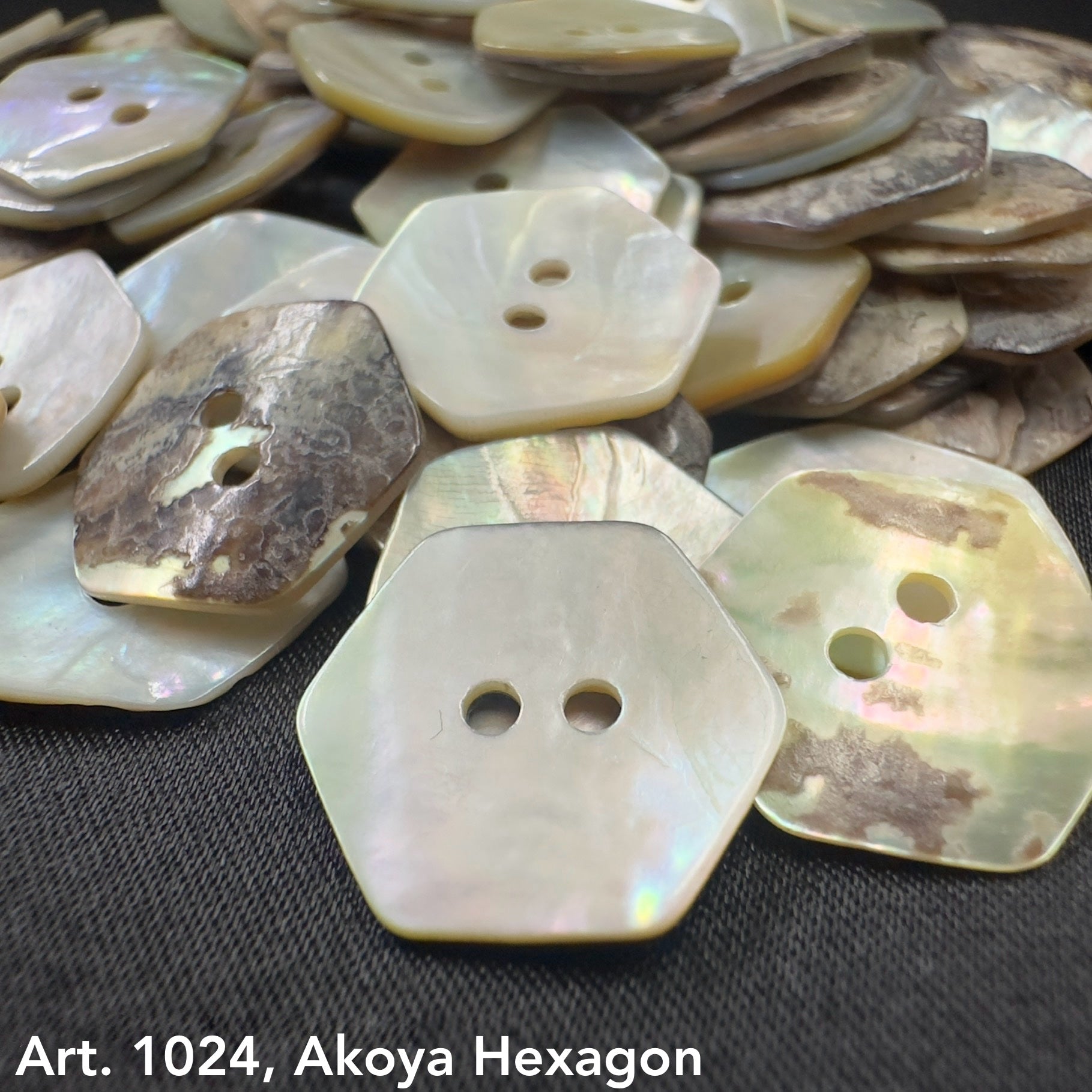 Close-up of Akoya hexagon buttons by Buttonology Inc with natural shell texture and two holes