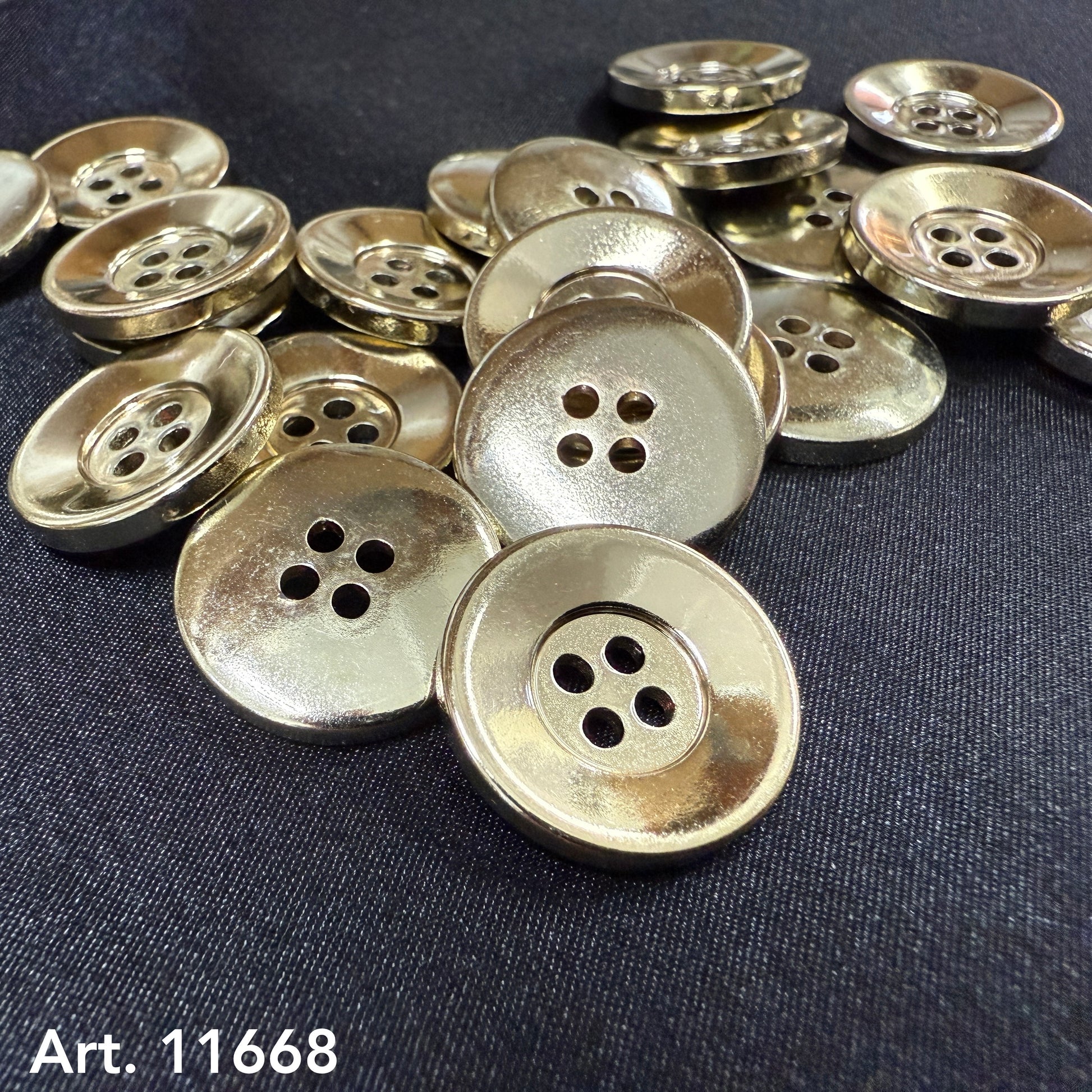 shiny gold 4-hole buttons by Buttonology Inc displayed on black fabric for sewing and craft projects