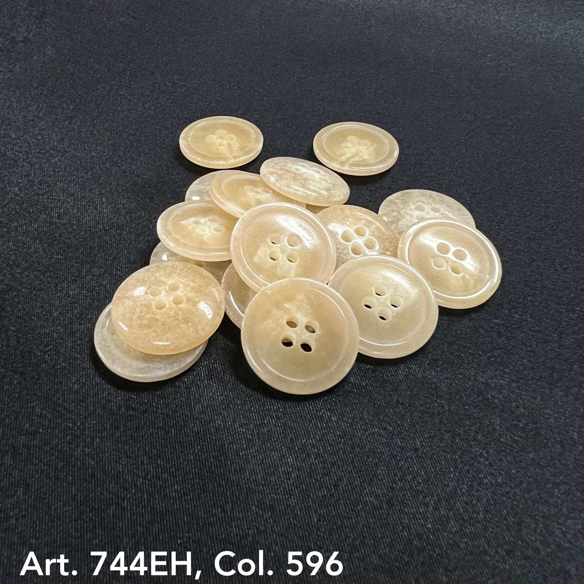 Buttonology Inc fort horn effect four hole buttons beige marbled sew through pile on black fabric background
