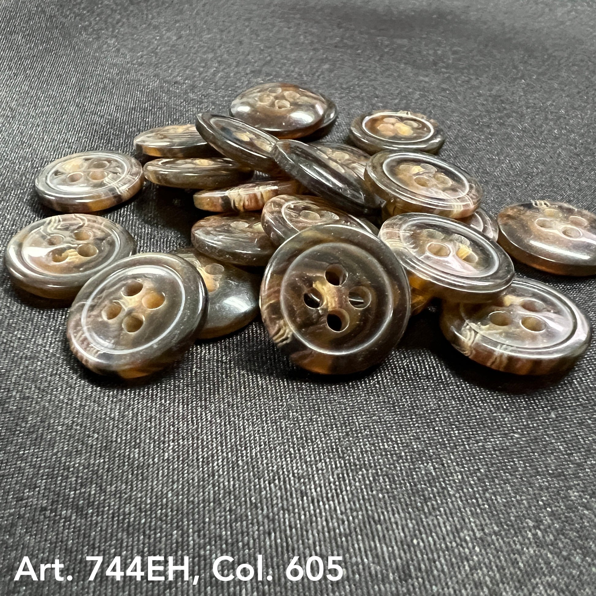 Buttonology Inc brown marbled fort horn effect four hole buttons stacked on black fabric showing glossy finish
