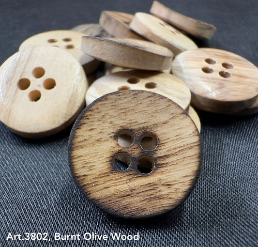 Burnt olivewood buttons by Buttonology Inc with a natural charred edge and four holes