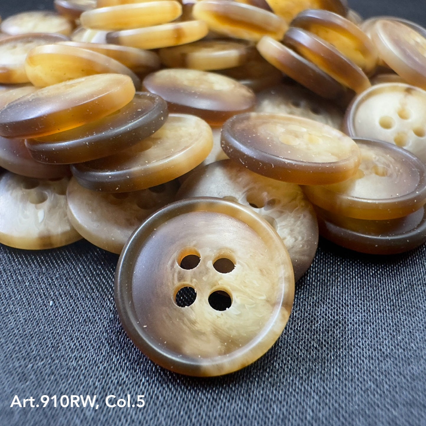 Buttonology Inc coat buttons for sewing caramel marbled round four hole buttons on dark fabric closeup