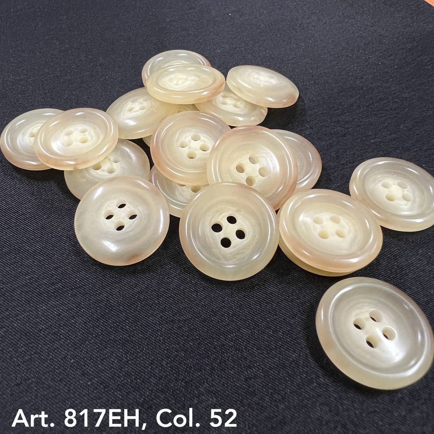 Pearl-like beige buttons from Buttonology Inc premium sewing buttons online displayed on black fabric