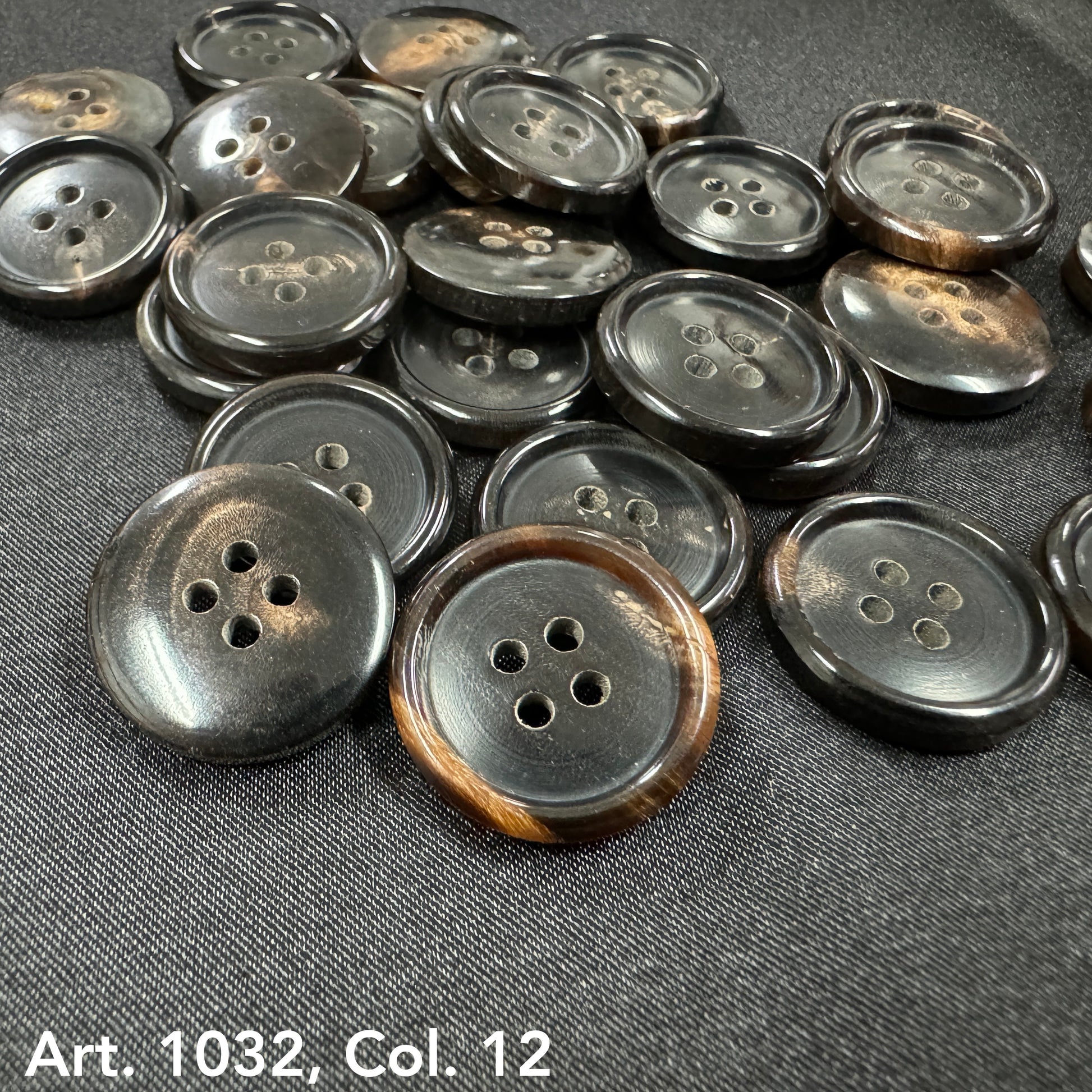 Buttonology Inc sustainable real horn buttons with four holes on black fabric background