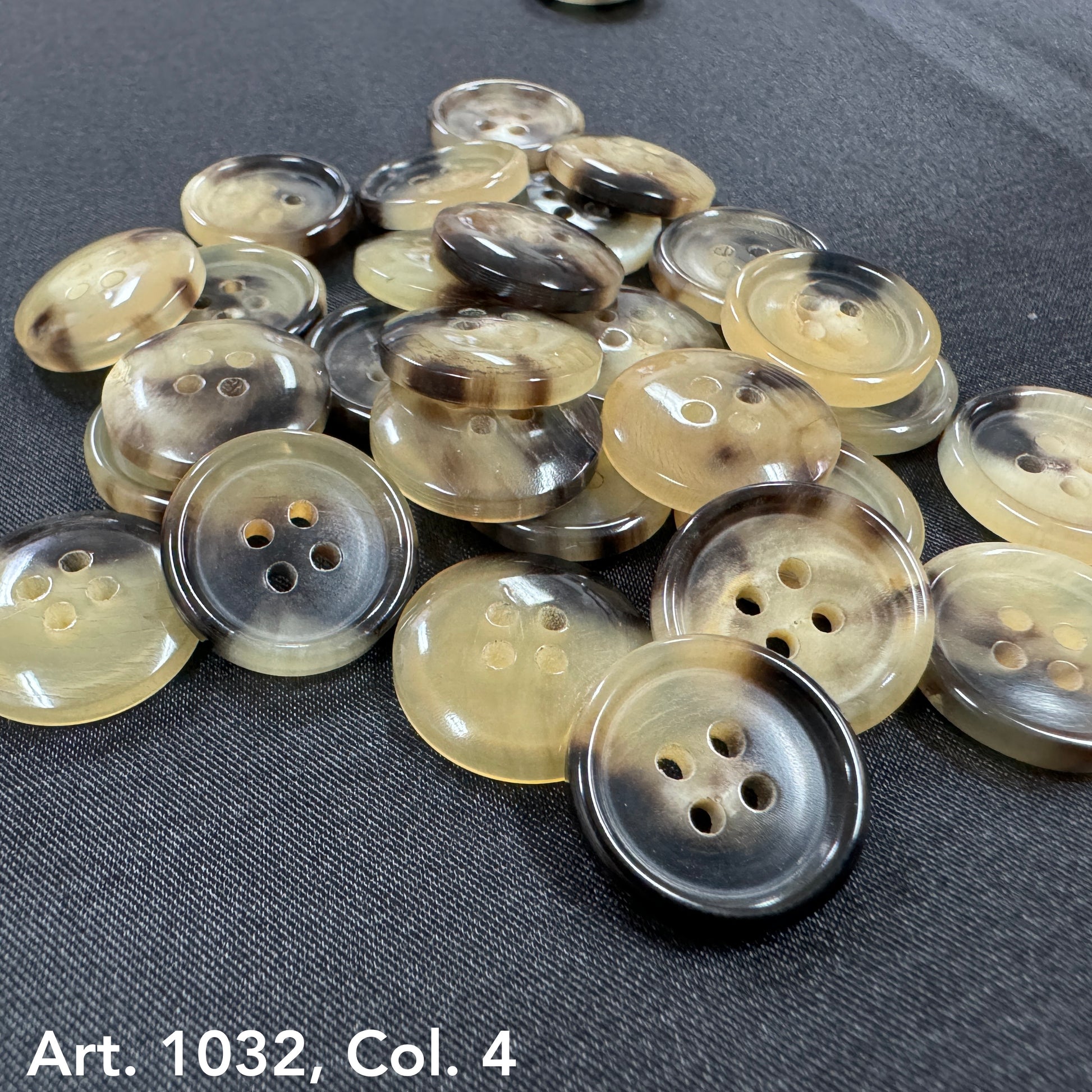 Pile of sustainable real horn buttons by Buttonology Inc in natural brown and beige tones with four holes