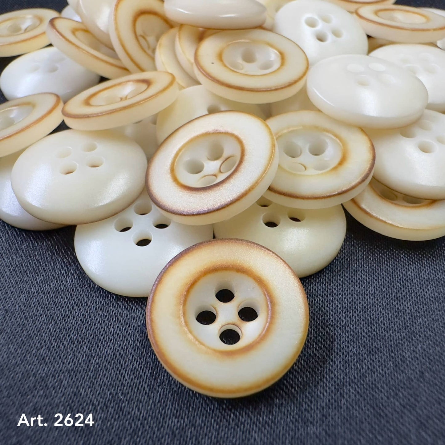 Burnt corozo buttons by Buttonology Inc with natural wood texture and four-hole design on dark fabric