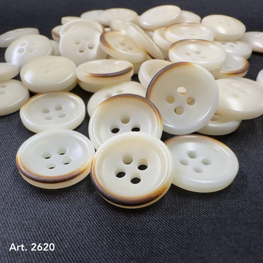 Burnt corozo buttons by Buttonology Inc with a natural brown edge on creamy white surface