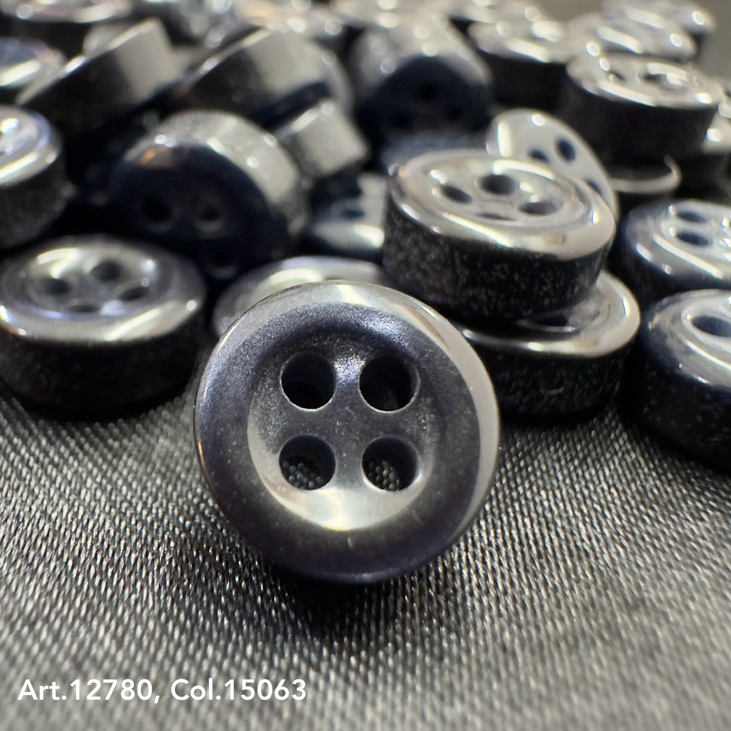 Close-up of black buttons with four holes from Buttonology quality button supply on textured surface