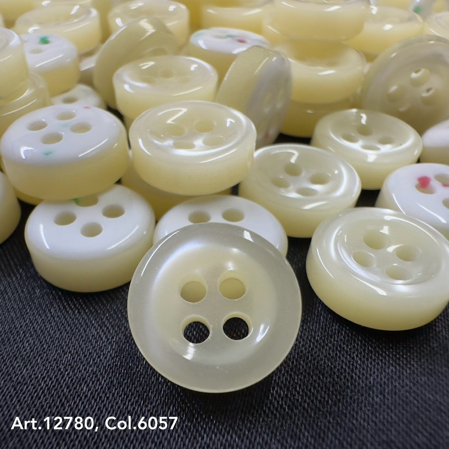 Close-up of cream and white buttons on black fabric from Buttonology quality button supply