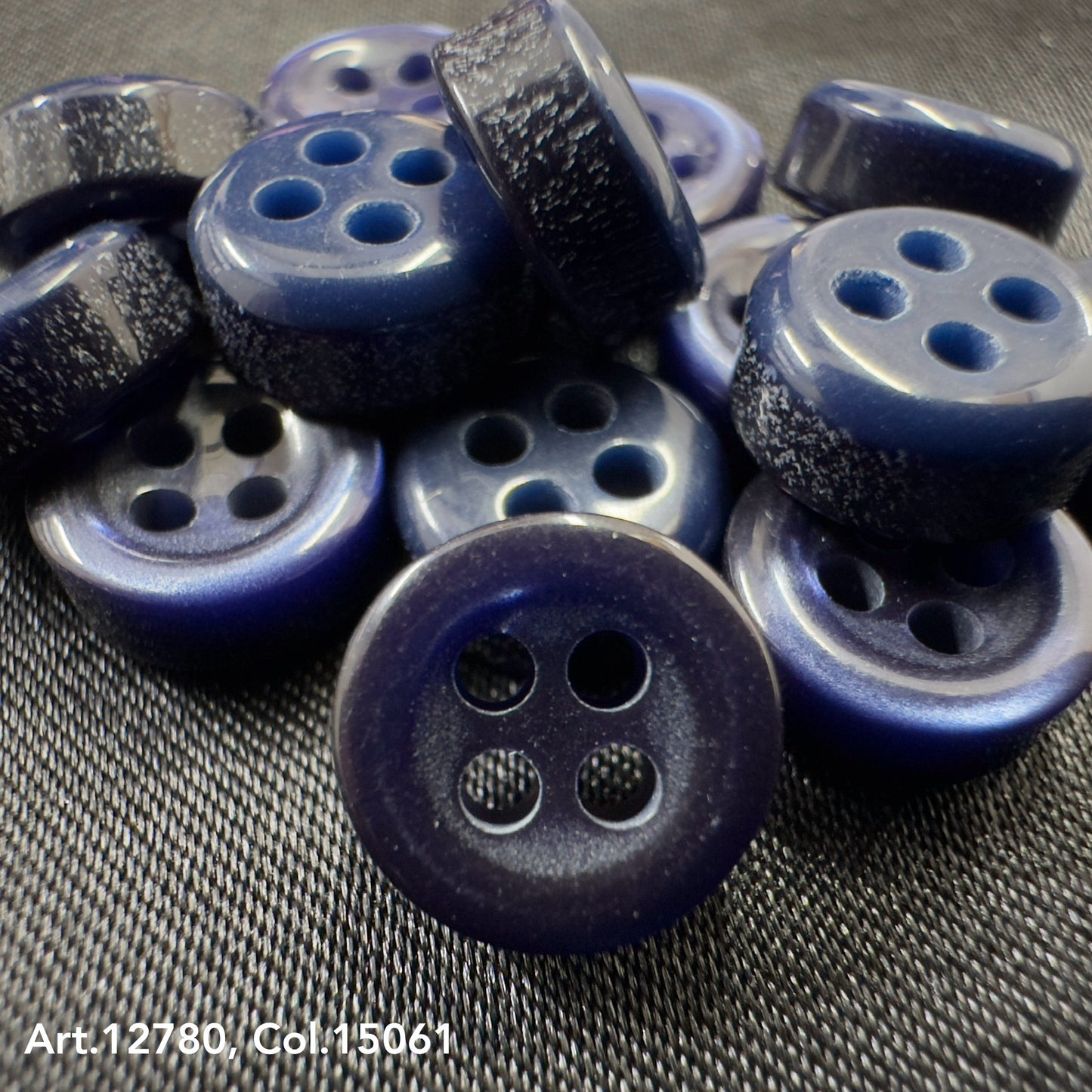 Close-up of blue buttons with four holes showcasing Buttonology quality button supply from Buttonology Inc
