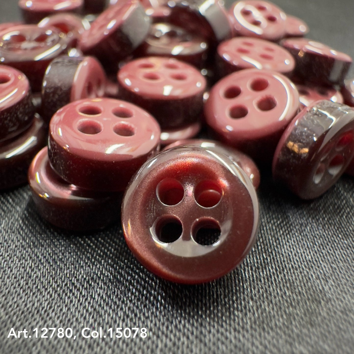 Buttonology quality button supply featuring glossy maroon four-hole buttons on black fabric
