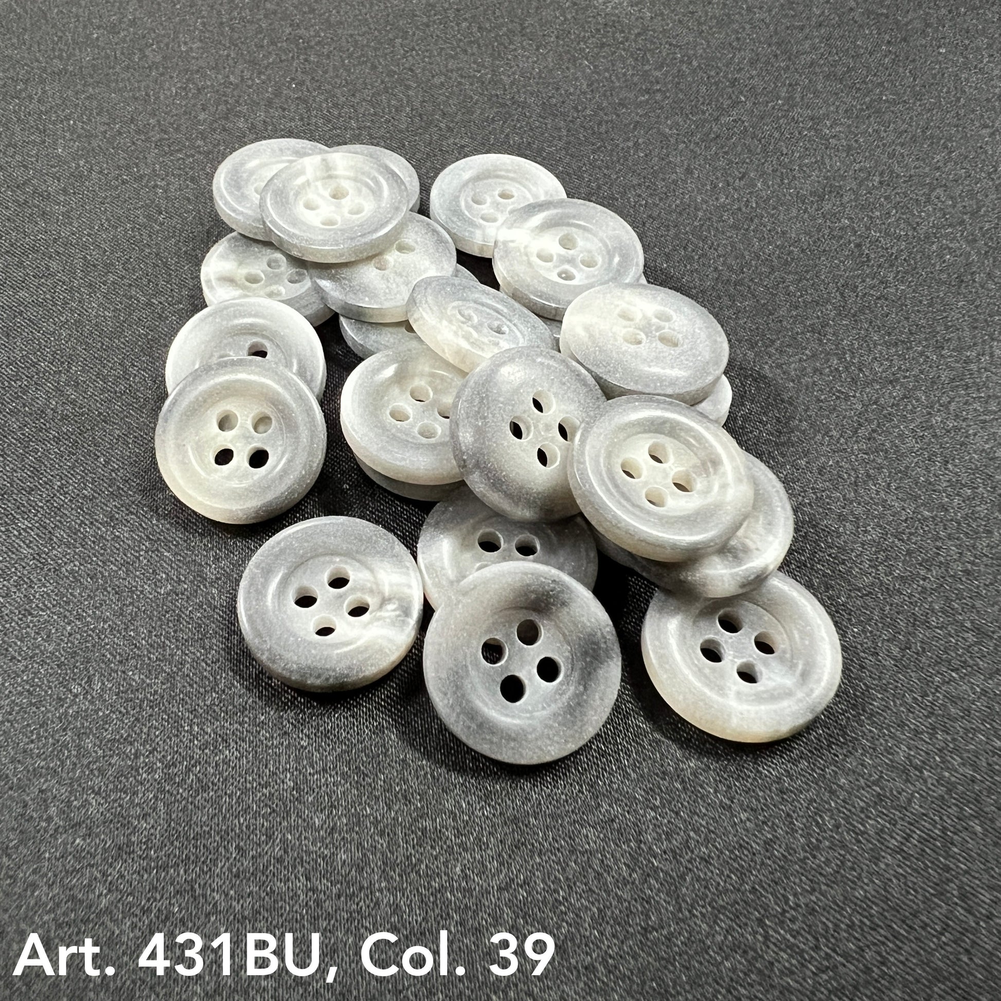 Gray and white marbled buttons with four holes on black fabric Buttons for sale by Buttonology Inc