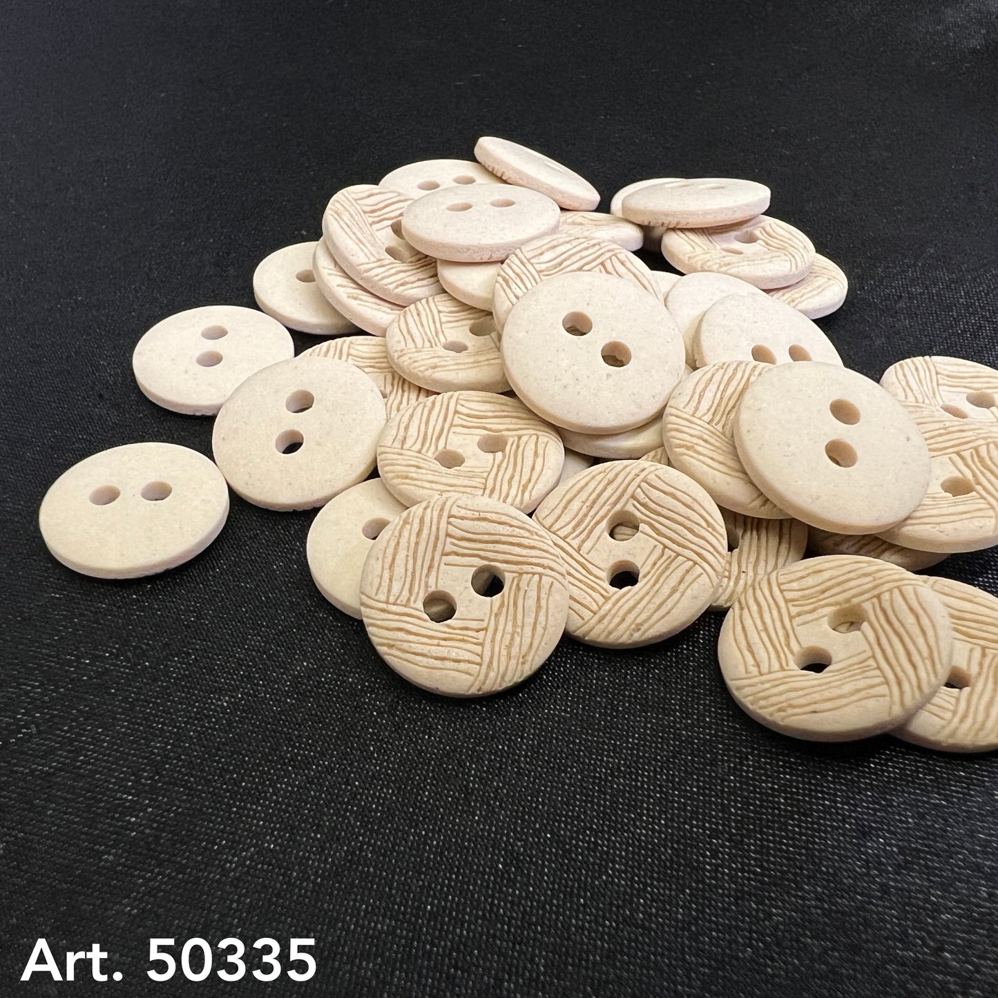 Pile of beige textured sewing buttons with two holes showing woodgrain and smooth finishes