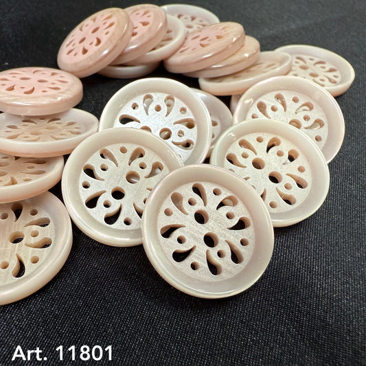 Decorative sewing buttons by Buttonology Inc with intricate cutout floral design in soft pink and white