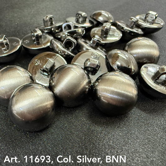 Designer clothes buttons silver by Buttonology Inc laid out on black fabric showing shiny round metal buttons