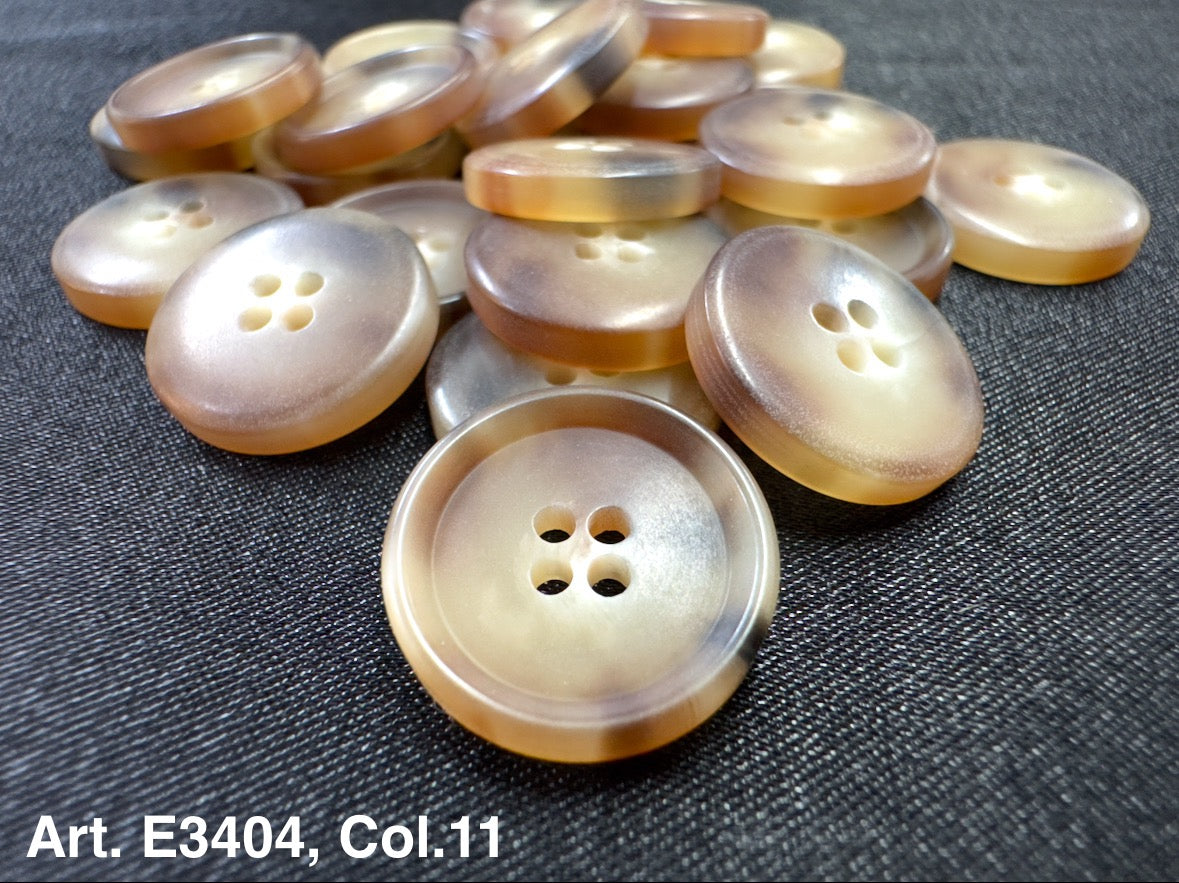 Buttonology Inc four hole sewing buttons pearlescent beige plastic buttons displayed on dark fabric