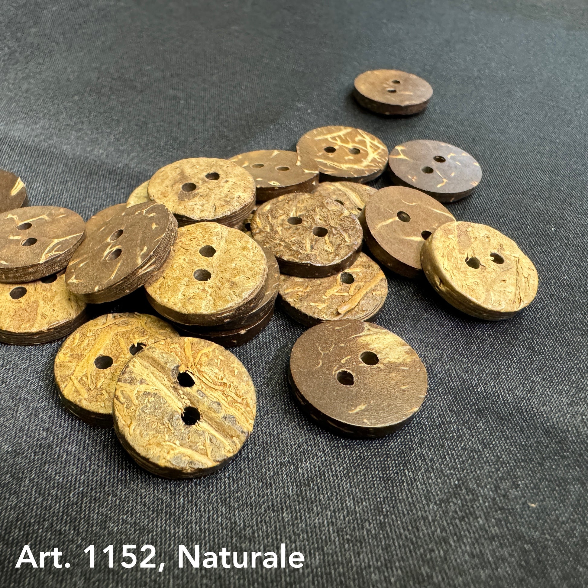 Eco-friendly coconut buttons by Buttonology Inc in natural brown shades on dark fabric background