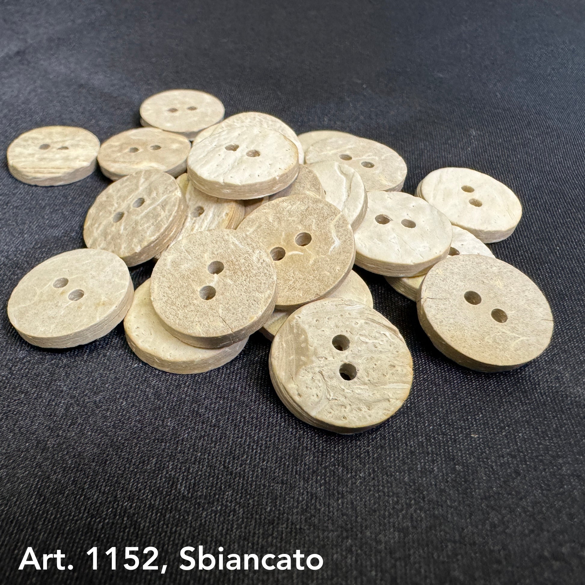 Eco-friendly coconut buttons by Buttonology Inc in natural beige color with two holes on black fabric