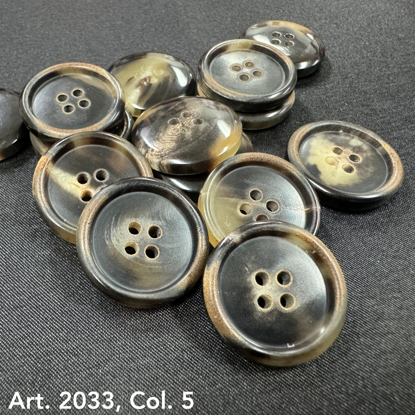 Eco-friendly horn buttons by Buttonology Inc with four holes and natural color variations