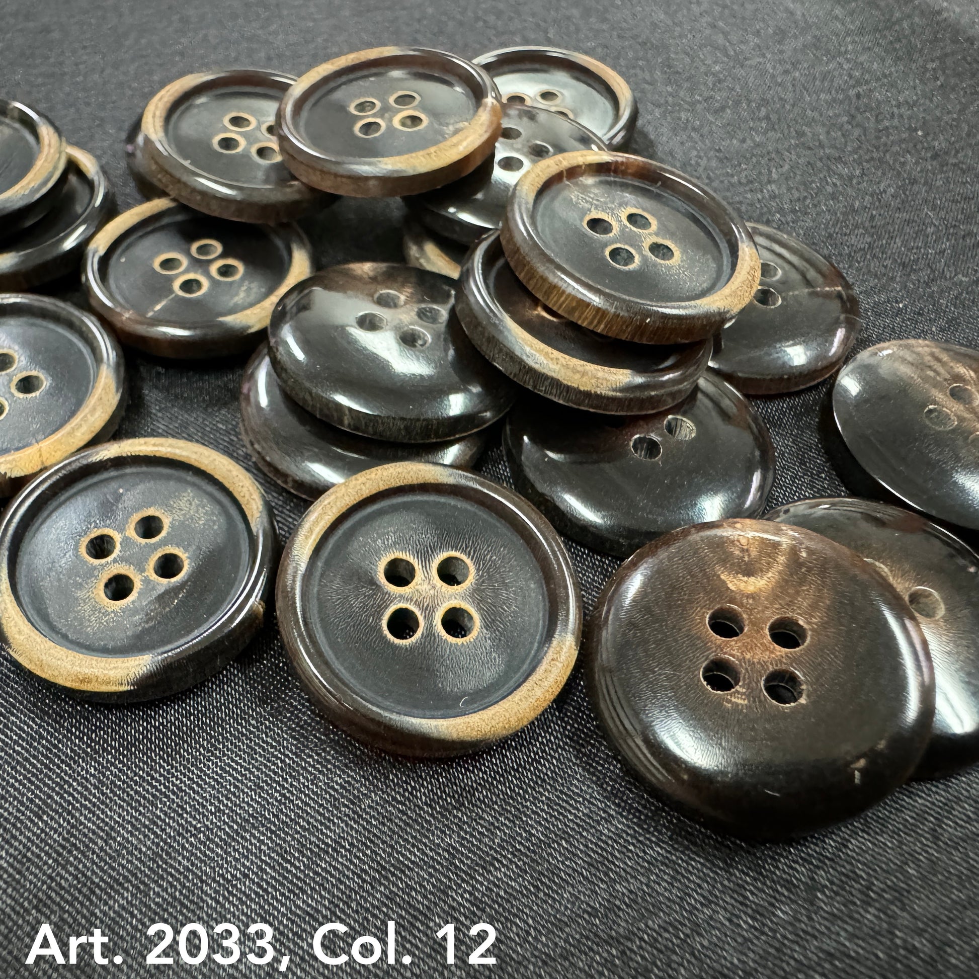 Eco-friendly horn buttons by Buttonology Inc scattered on black fabric with natural brown and black tones