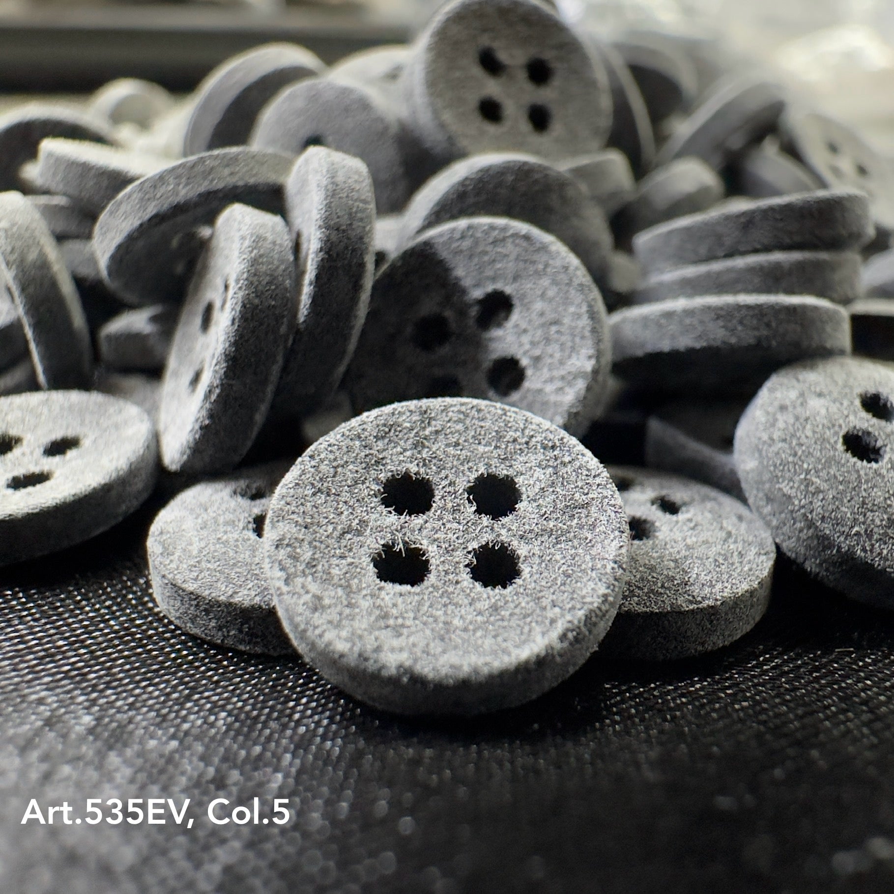Eco-Velvet buttons by Buttonology Inc in gray with a soft textured surface and four holes