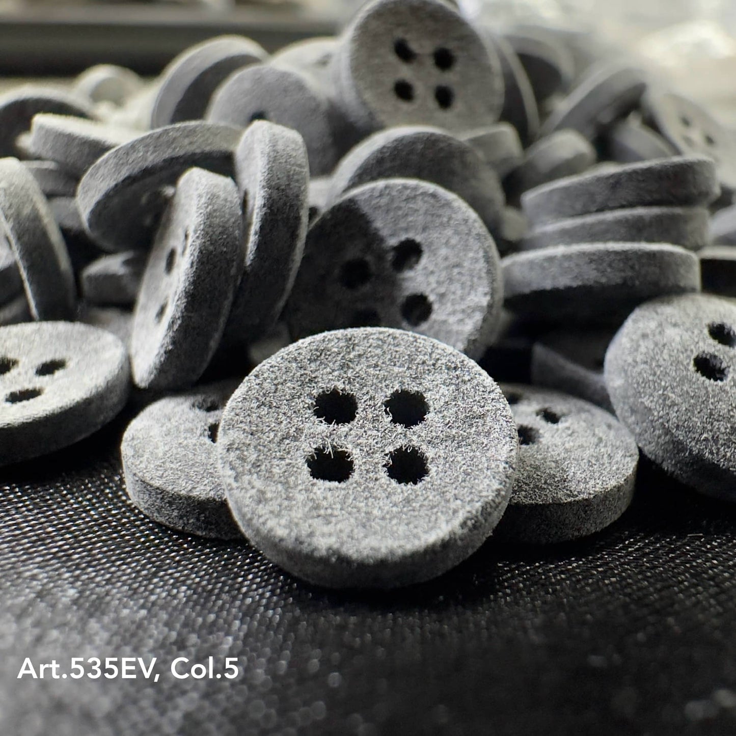 Eco-Velvet buttons by Buttonology Inc in gray with a soft textured surface and four holes