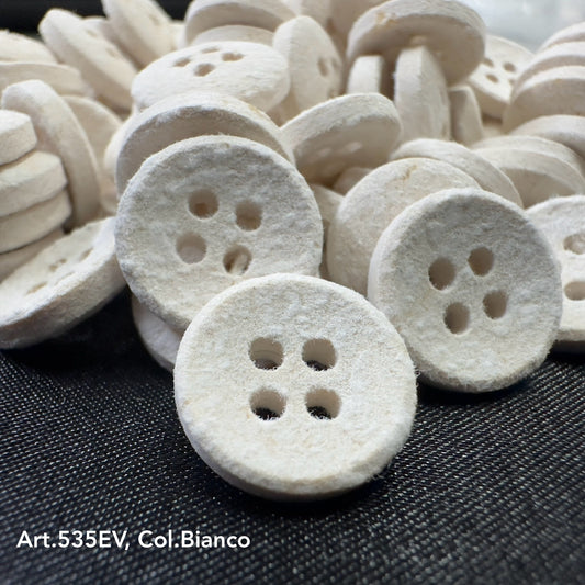 Eco-Velvet white textured buttons with four holes by Buttonology Inc on black fabric background
