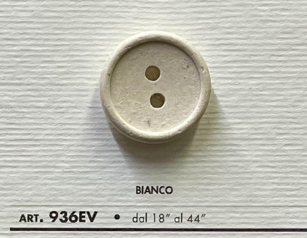 Eco-Velvet Eco-Friendly white two-hole button by Buttonology Inc on textured background