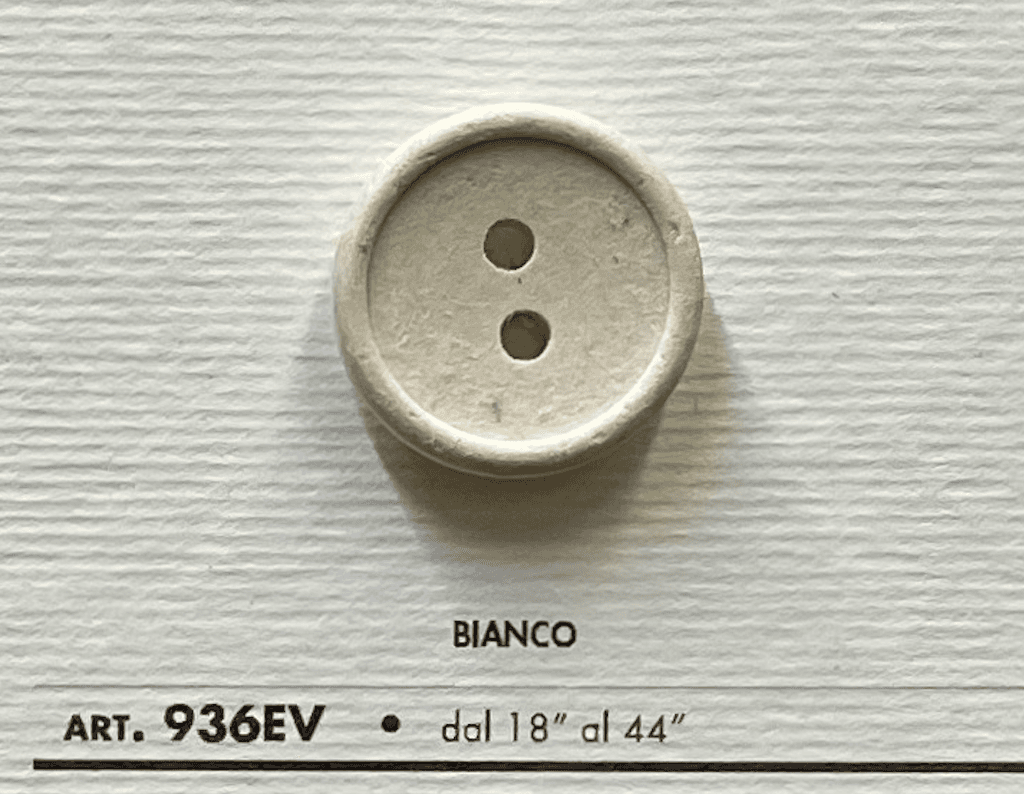 Eco-Velvet Eco-Friendly white two-hole button by Buttonology Inc on textured background