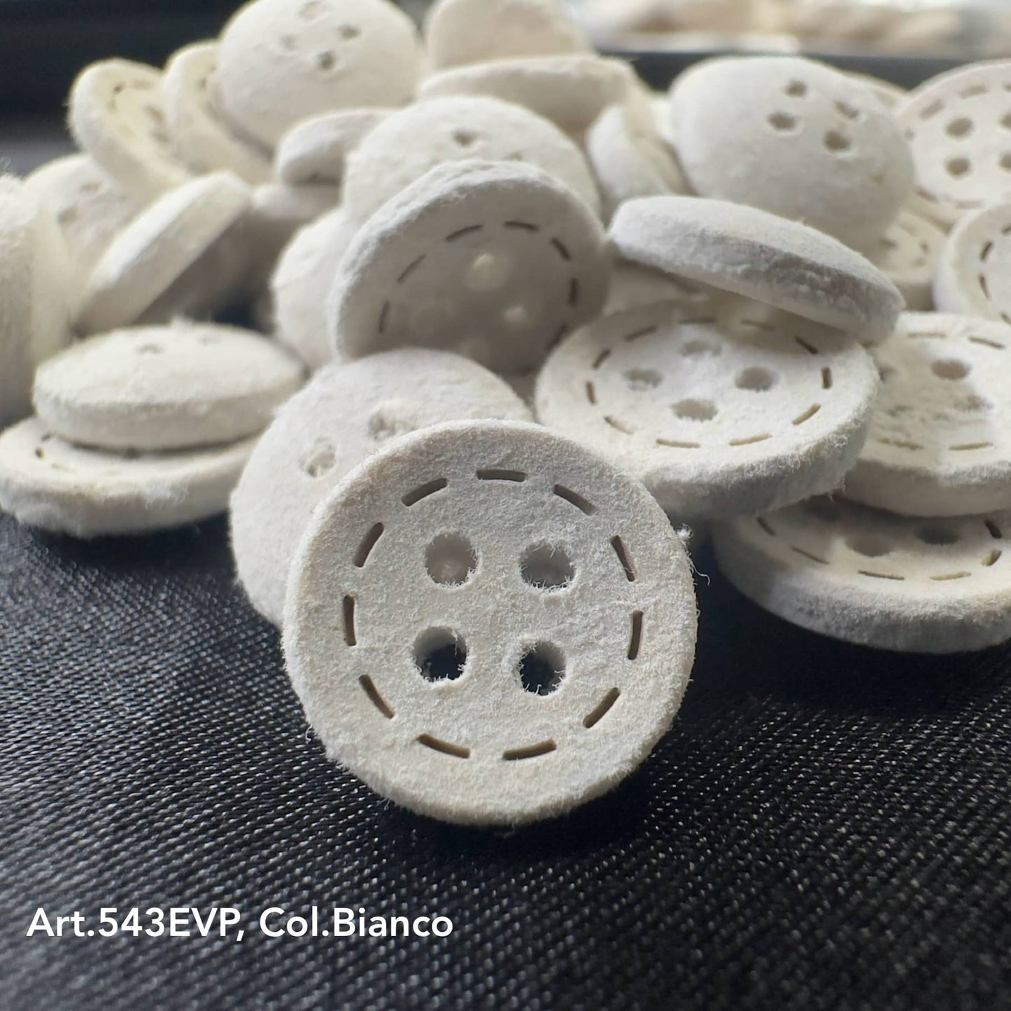 Eco-Velvet Eco-Friendly white fabric buttons by Buttonology Inc with four holes and stitched detail