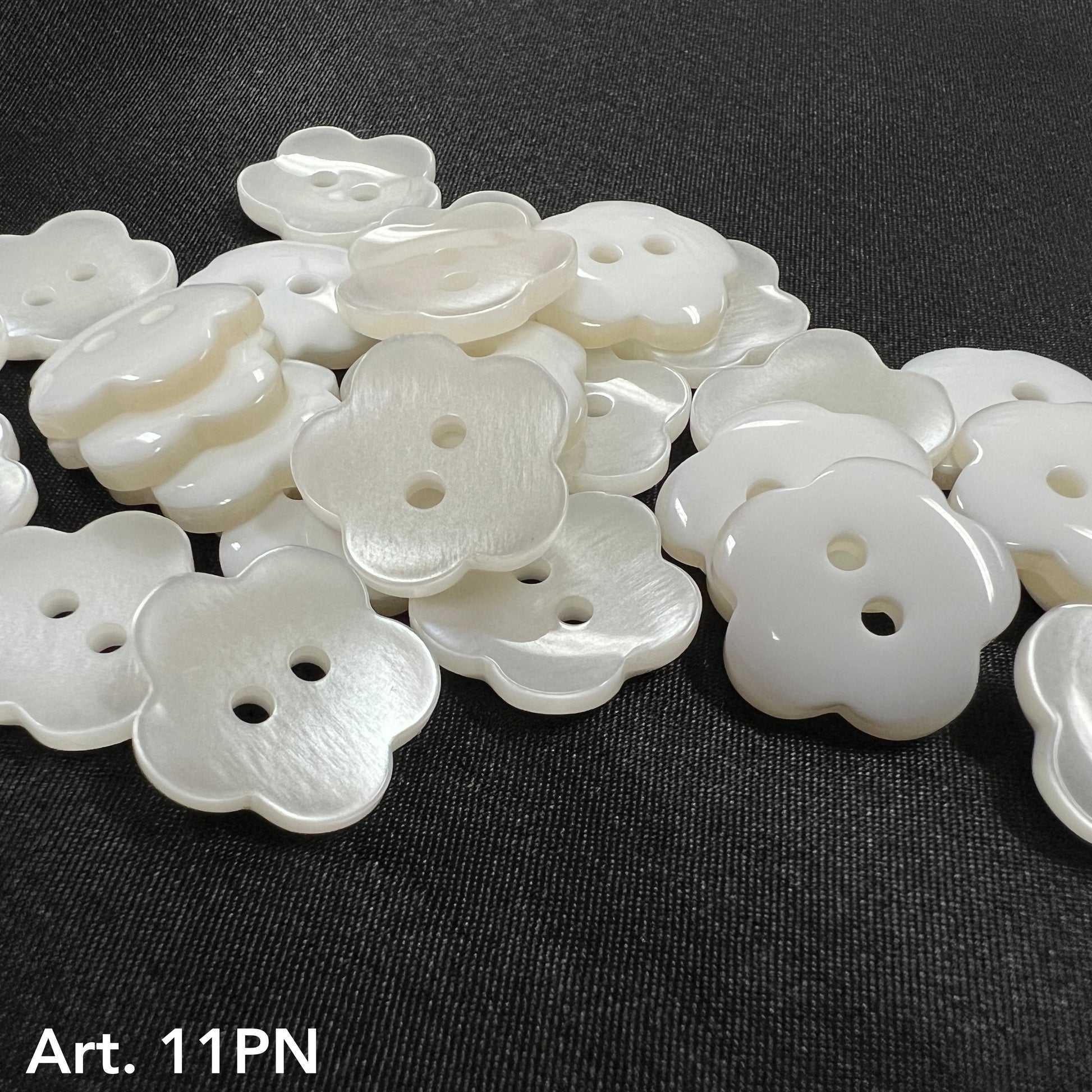 Flower shaped pearl buttons by Buttonology Inc. with a glossy finish and two holes for sewing