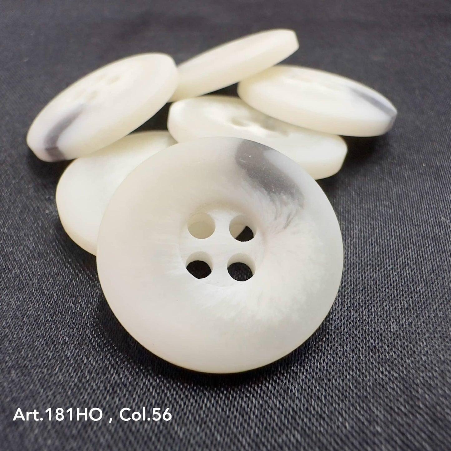 White polyester resin sewing supplies buttons with four holes on black fabric background