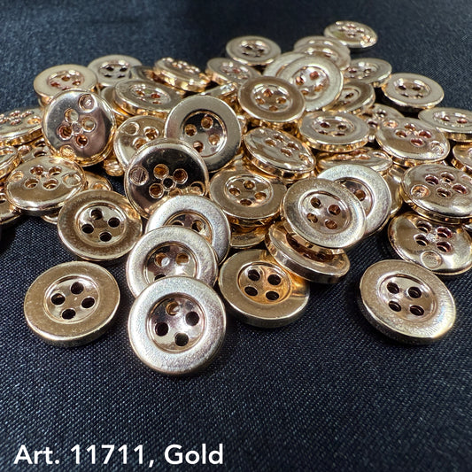 Gold sewing buttons from Buttonology Inc scattered on black fabric background