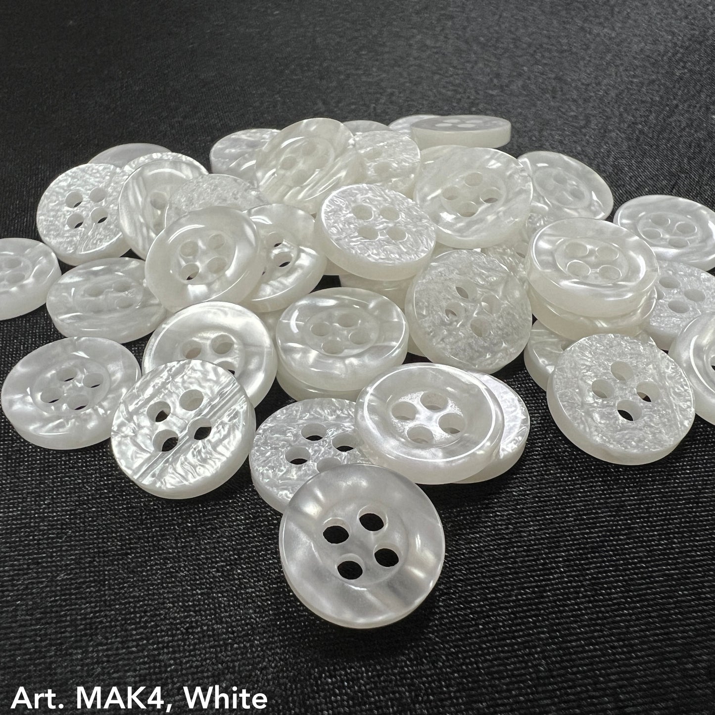 White assorted buttons by Buttonology Inc showing how to choose buttons for DIY clothes projects