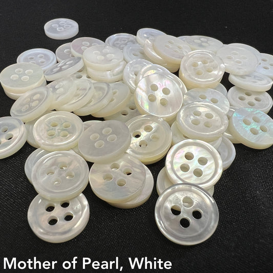 Close-up of white mother of pearl buttons by Buttonology Inc with four holes on black background