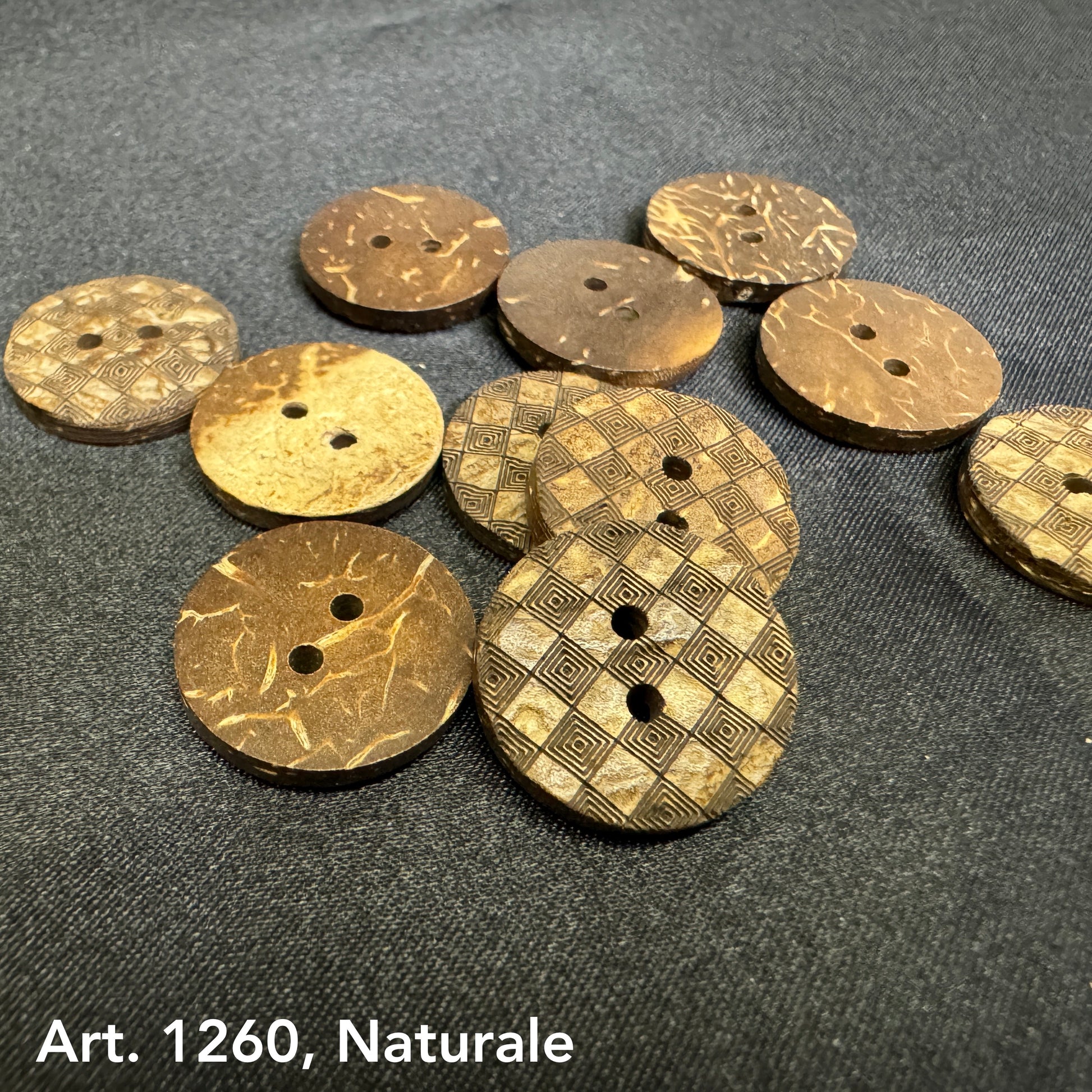 Assorted natural coconut buttons with engraved patterns from Buttonology Inc on dark fabric