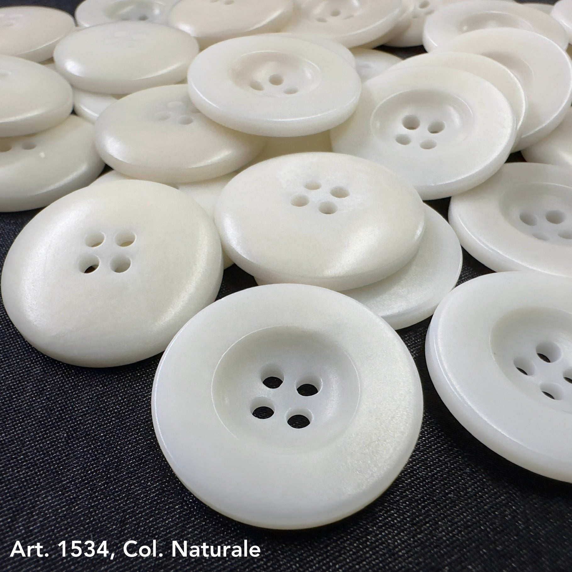 White natural corozo buttons with four holes in assorted sizes from Buttonology Inc