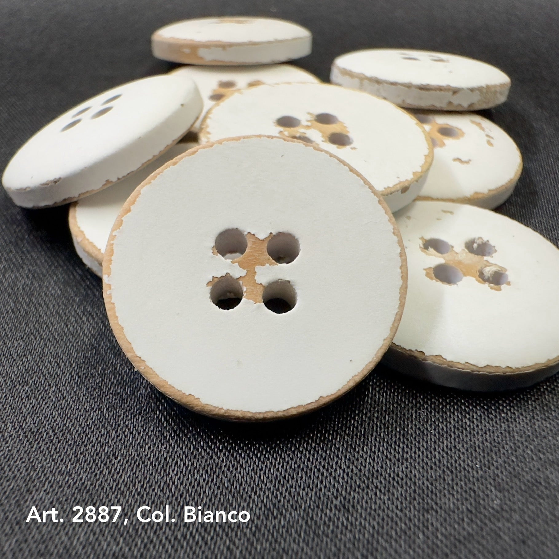 Natural wood buttons for crafts in a variety of sizes arranged on a dark background