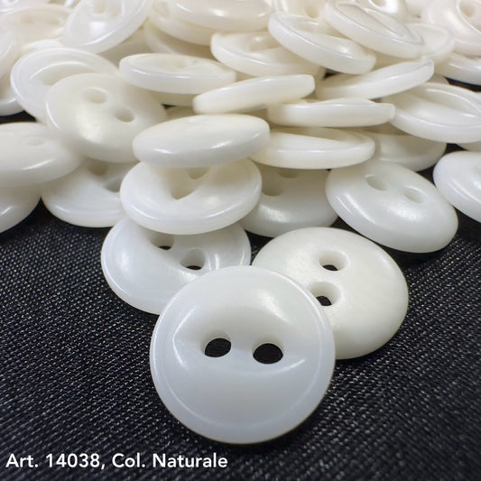 Premium corozo buttons two hole in natural color by Buttonology Inc scattered on dark fabric