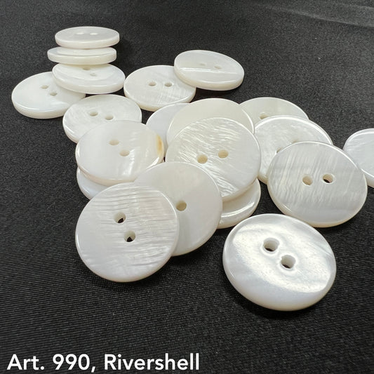 Premium shell buttons for sewing in white with two holes arranged on a black surface by Buttonology Inc