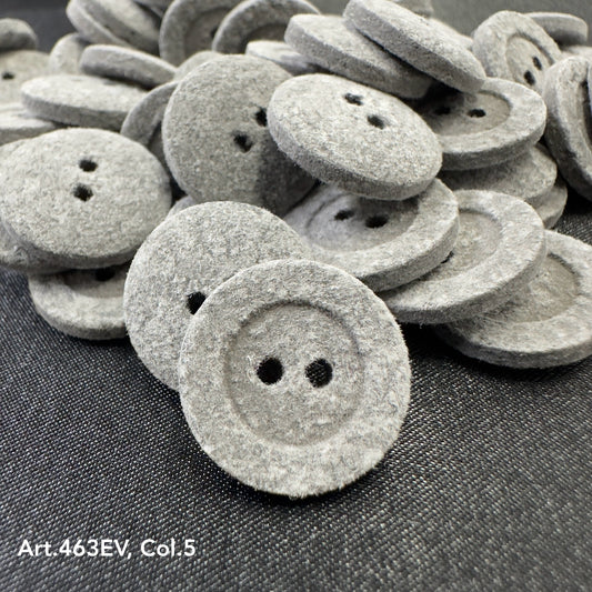 Close up pile of soft gray velvet buttons for sewing on dark fabric showing two hole velvet button texture