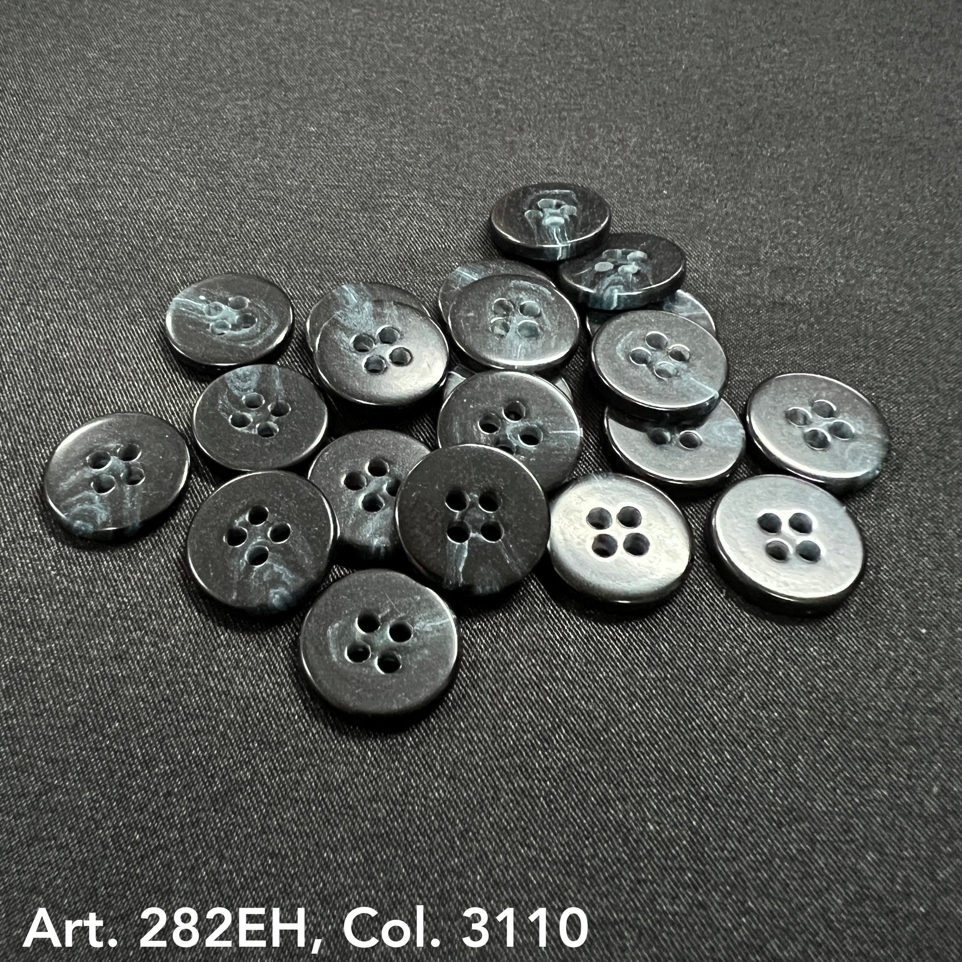 Black and gray shirt size buttons by Buttonology Inc arranged on black fabric background