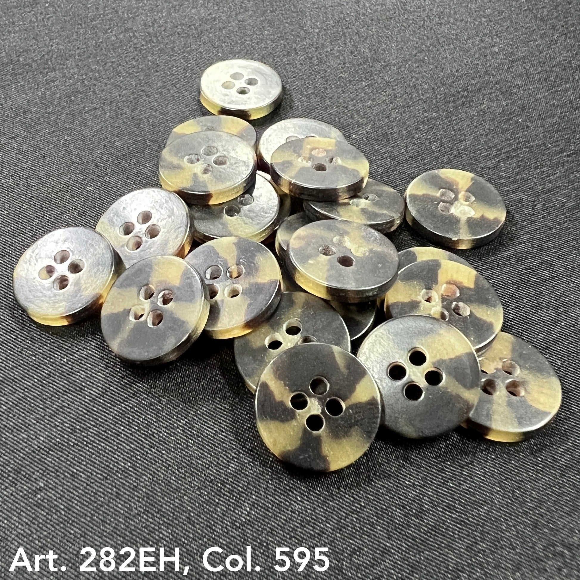 Buttonology Inc shirt size buttons with four holes in a tortoiseshell pattern on black fabric