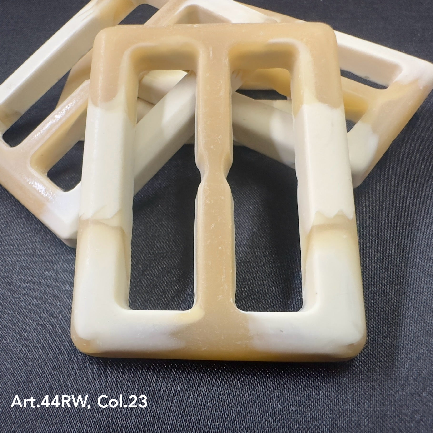 Buttonology Inc beige and white strong polyester buckles with rectangular shape on black background