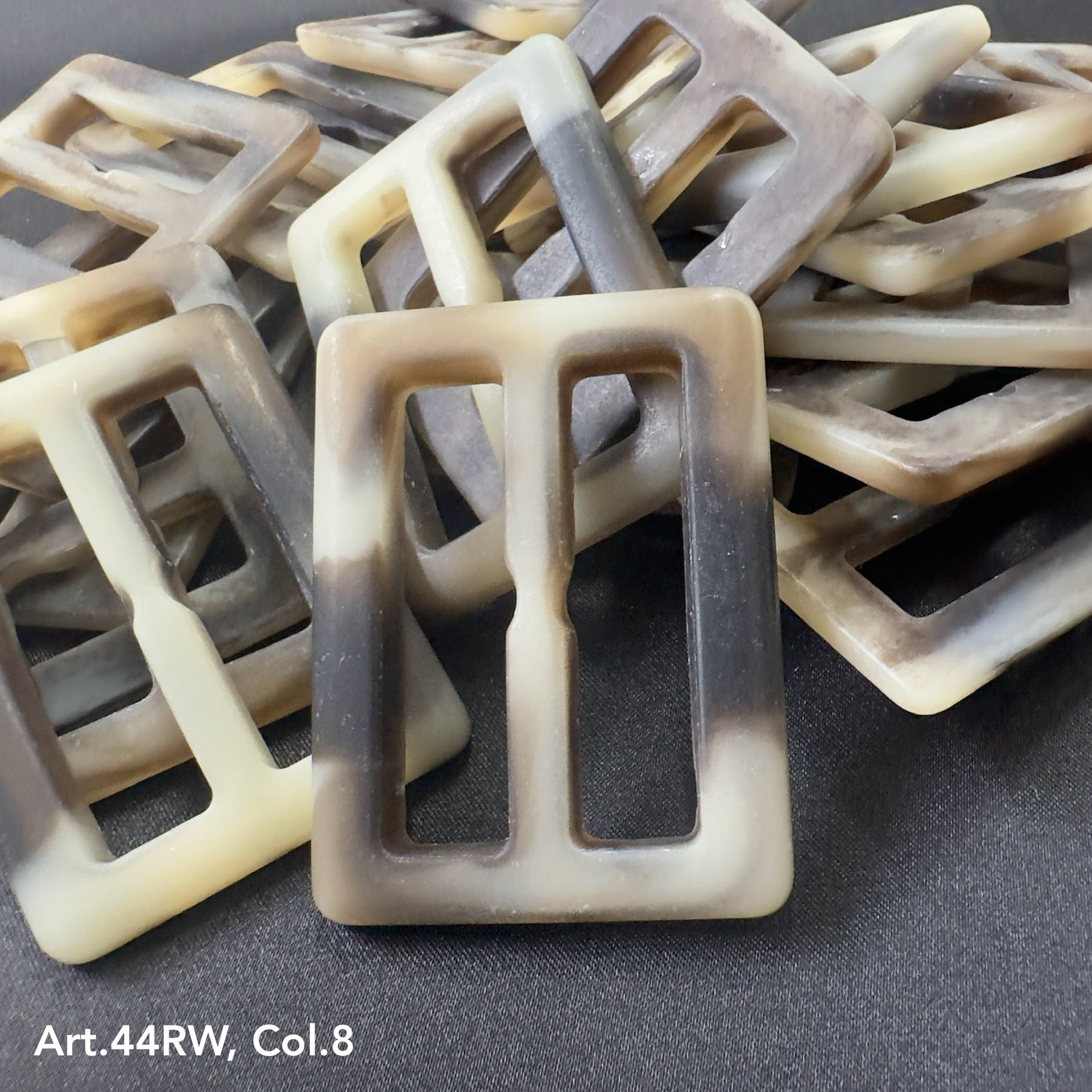 Strong polyester buckles in a marbled beige and black pattern by Buttonology Inc.