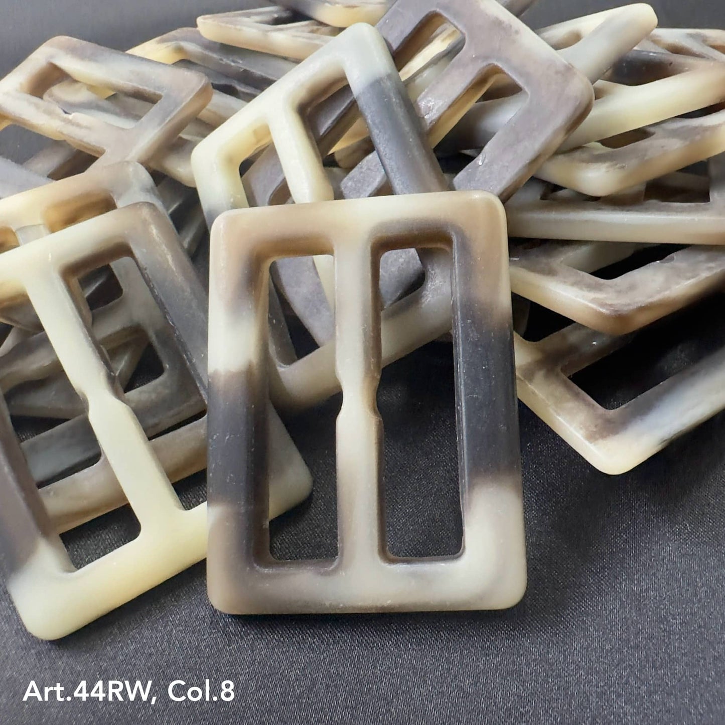 Strong polyester buckles in a marbled beige and black pattern by Buttonology Inc.