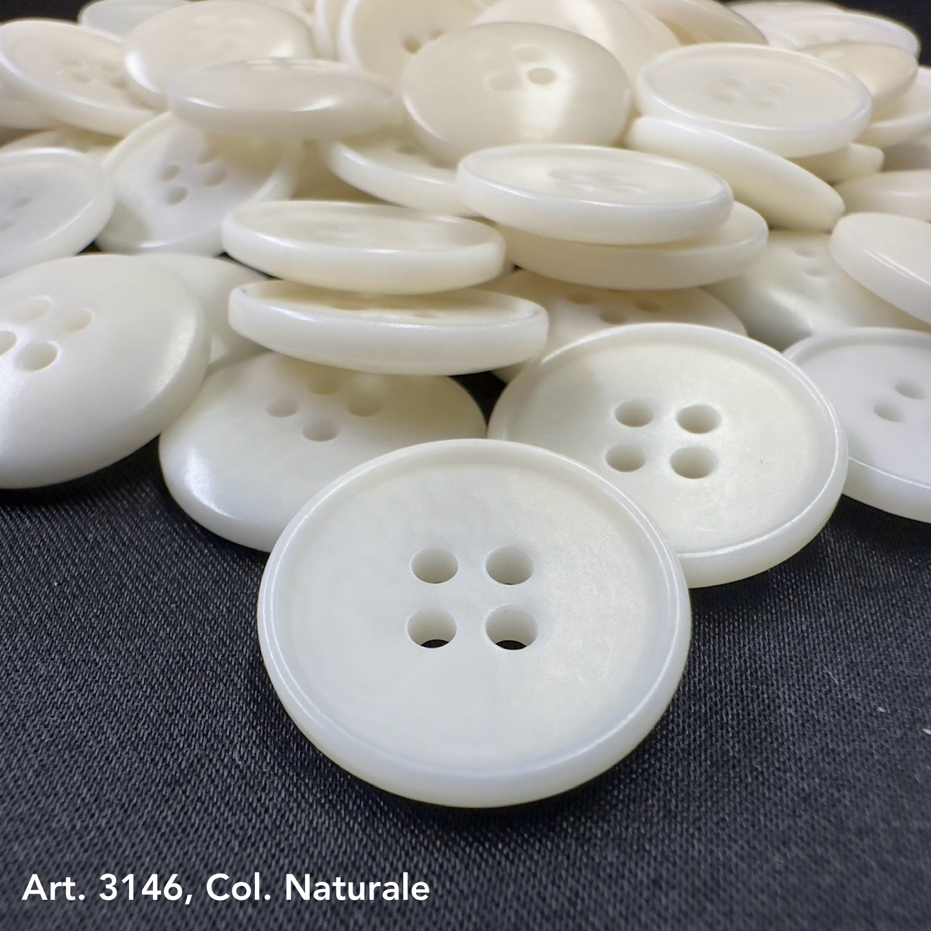 Sustainable corozo button wholesale white four-hole buttons by Buttonology Inc on black surface