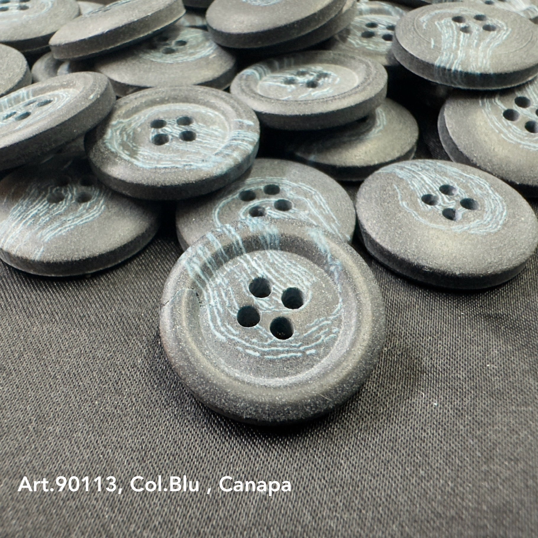 Close-up of sustainable Hemp buttons by Buttonology Inc with a textured blue-gray finish