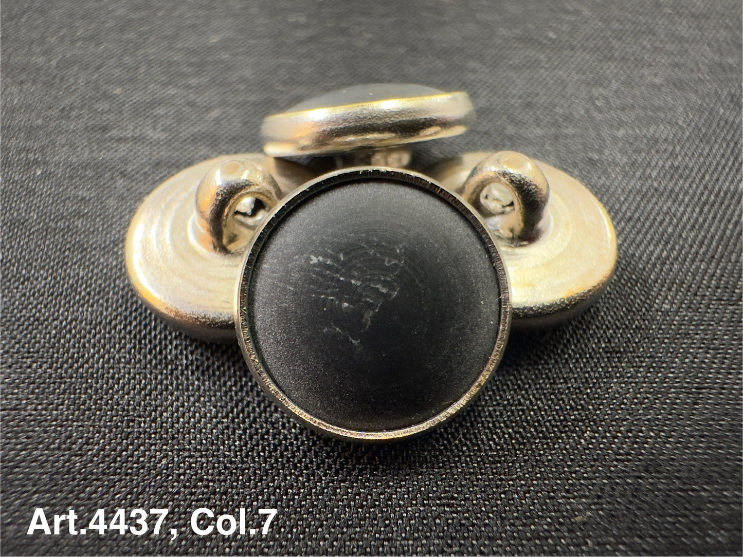 Buttonology Inc black Urea shank buttons with a smooth finish arranged on black fabric